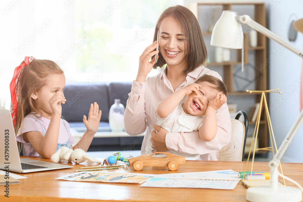 Working mother with naughty little children at home