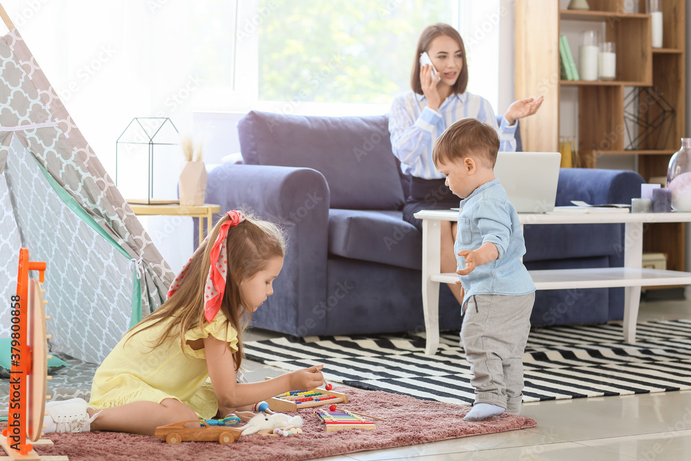 Working mother with little children at home