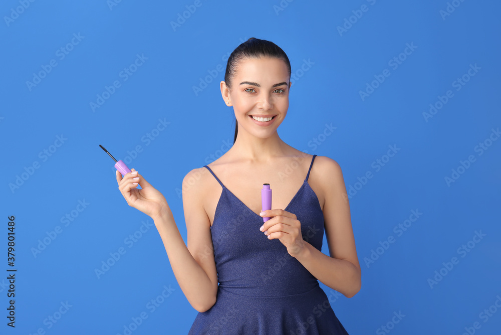 Beautiful young woman with mascara on color background