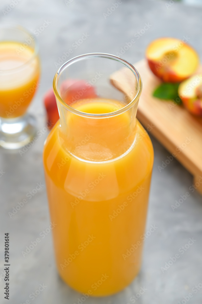 Bottle of fresh peach juice on table