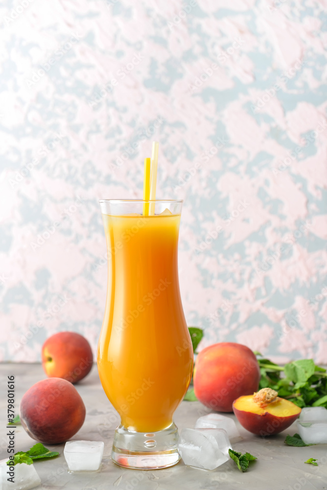 Glass of fresh peach juice on table