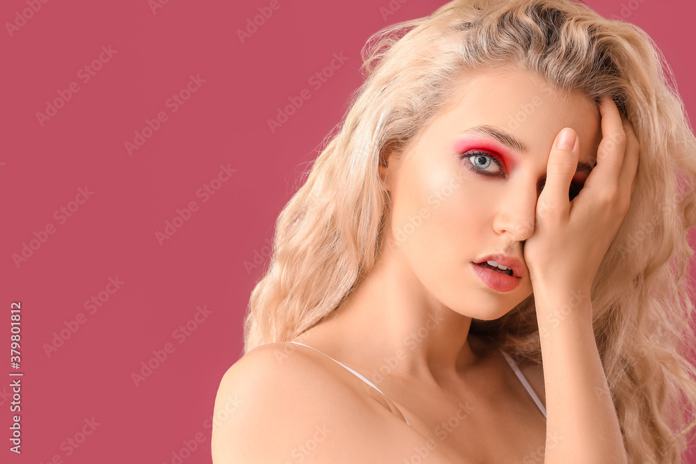 Young woman with beautiful eyeshadows on color background