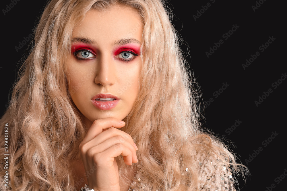 Young woman with beautiful eyeshadows on dark background