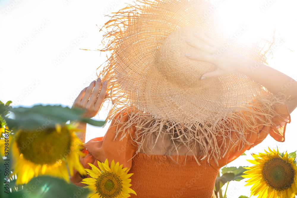 Beautiful young woman in sunflower field