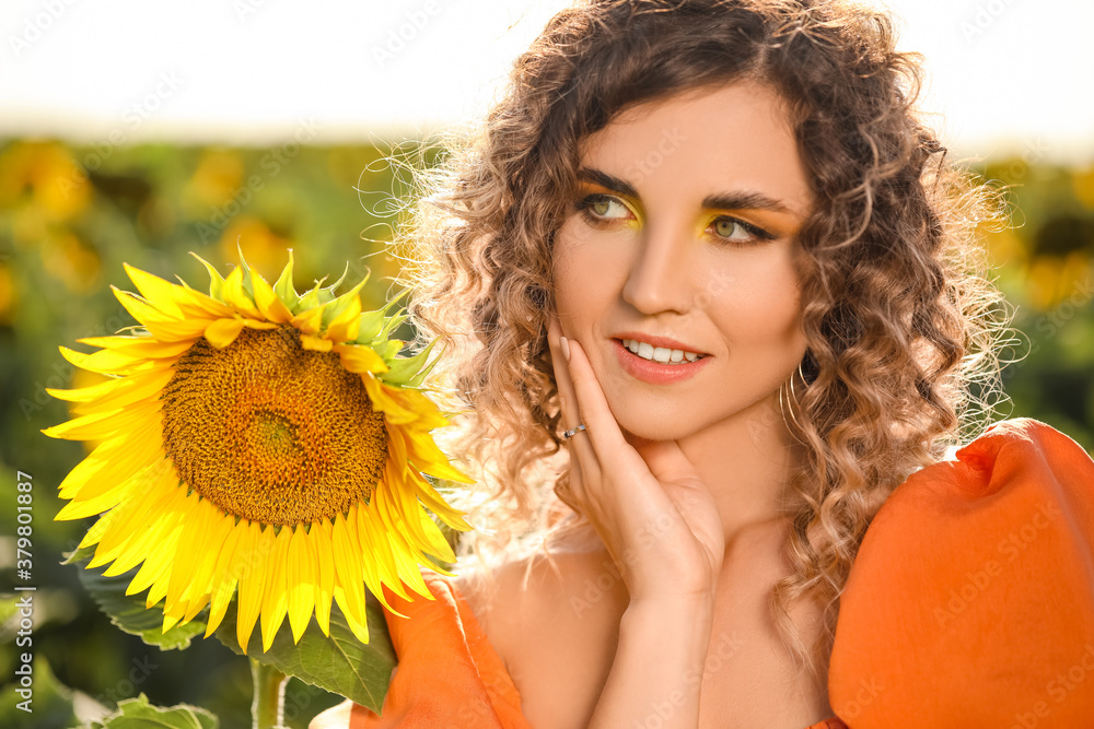 Beautiful young woman in sunflower field