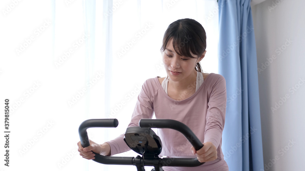 エアロバイクをこぐ女性