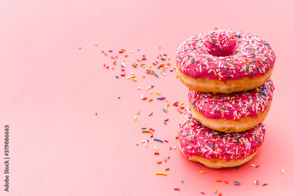 Pink berry donuts close up. Glazed and sprinkles bakery