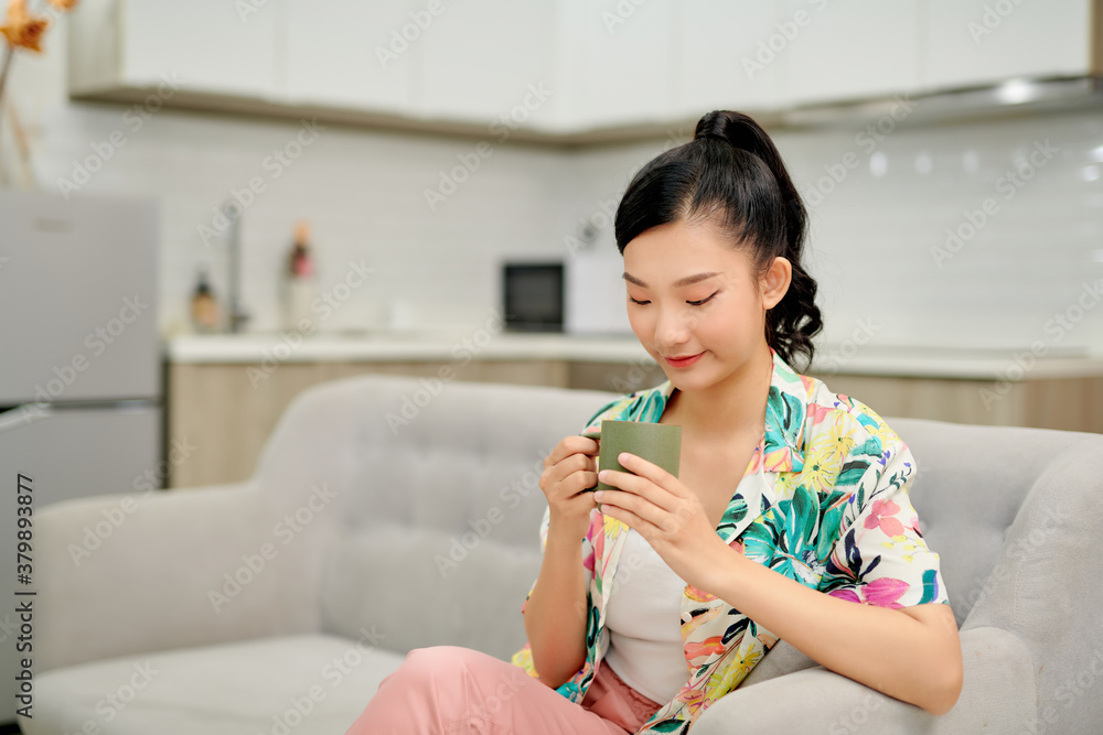 Woman drinking coffee on sofa