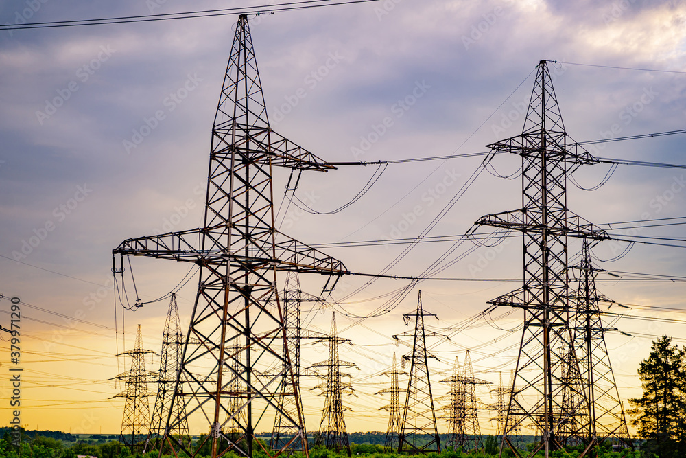 High voltage electric tower. Silhouette on sunset time. Power pylons on sunset time background. Sele