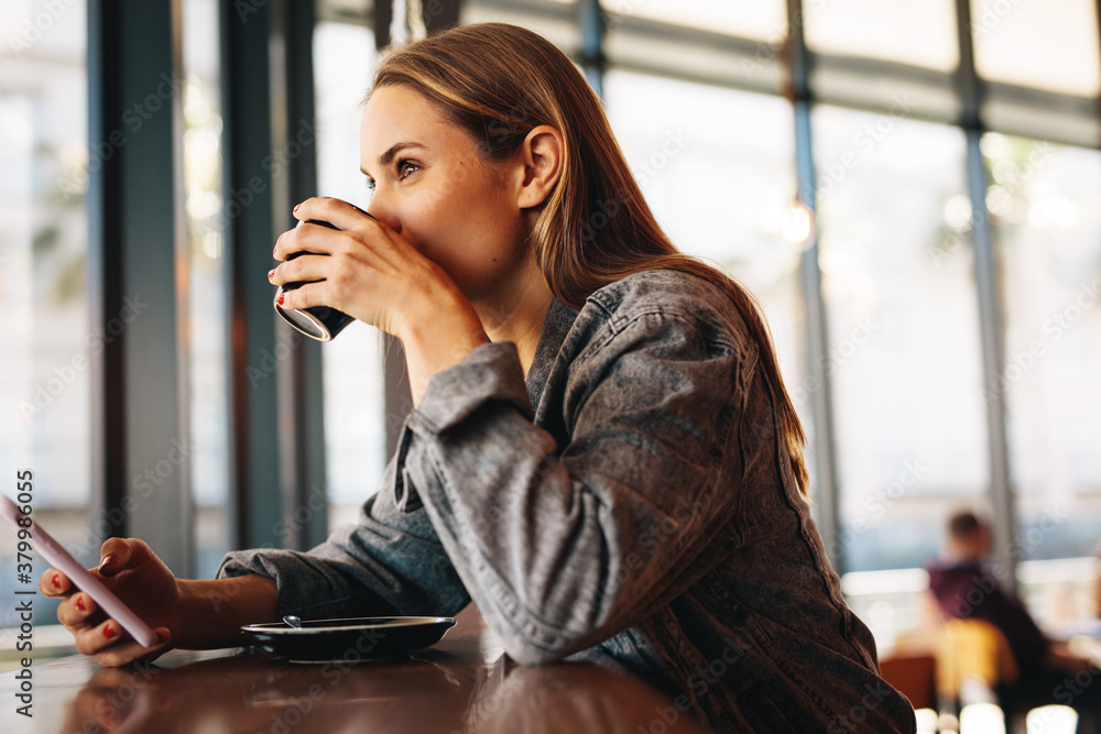 Woman having refreshing coffee at a cafe