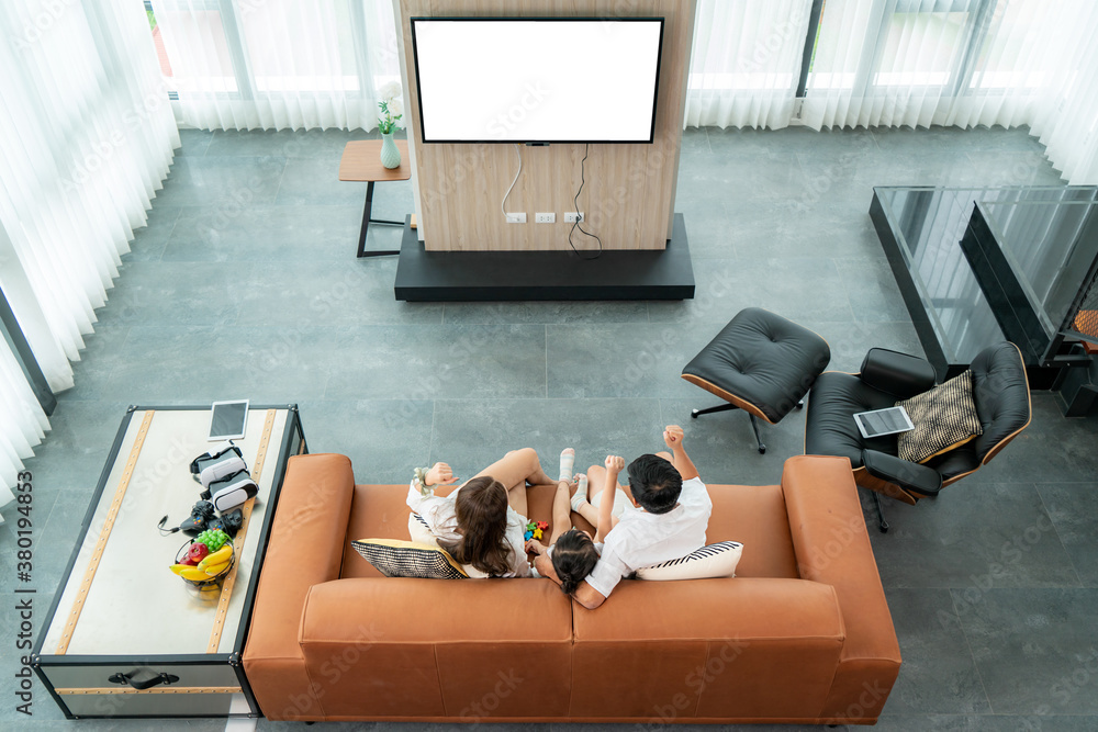 Top view of Asian happy family sitting and watching television in living room at home and spent qual