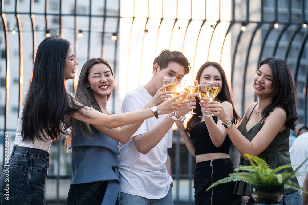 Group of Asian young man and woman 
clinking glasses and enjoy party.