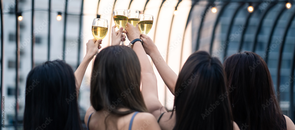 Group of Asian young people hold wine glass and clink glasses in party