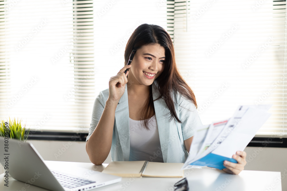 Smart Asian woman feeling happy that she can solve credit card problem