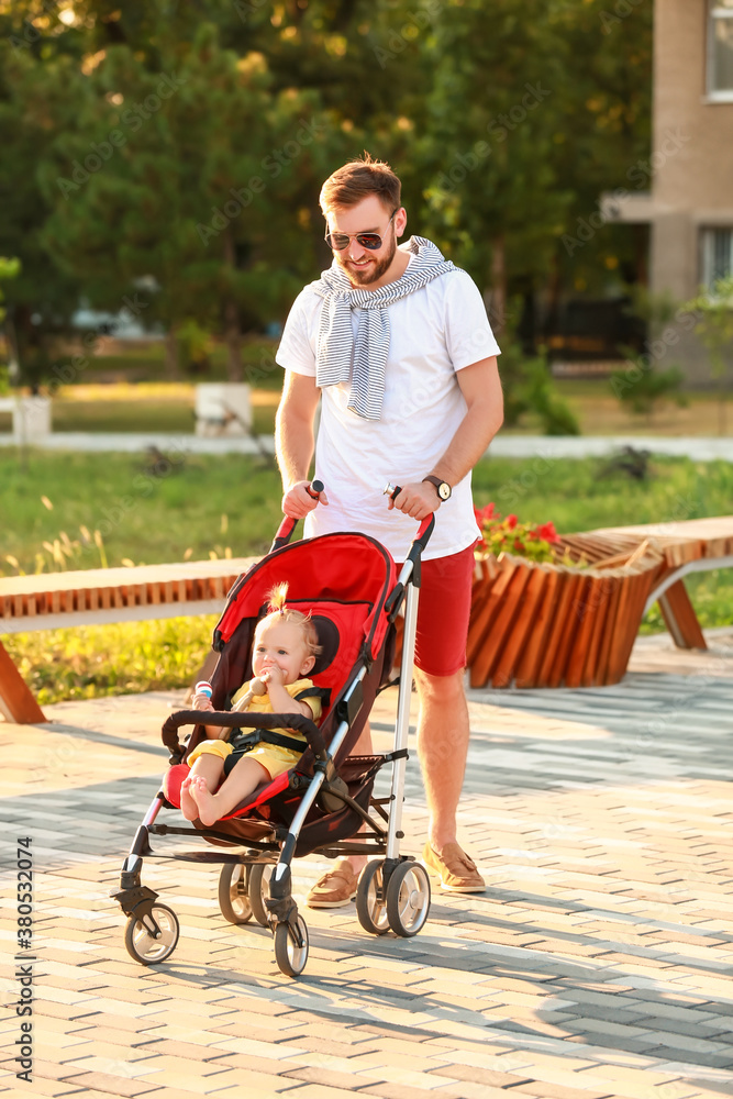 Man and his cute baby in stroller outdoors