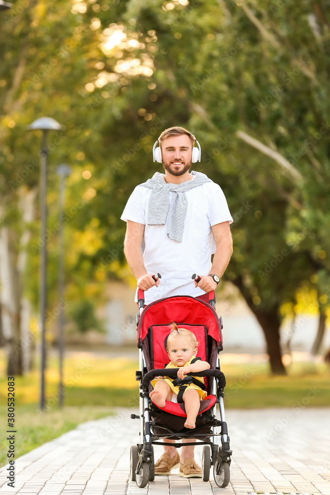 Man and his cute baby in stroller outdoors