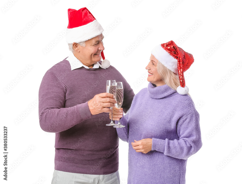 Elderly couple in Santa hats drinking champagne on white background. New Year celebration