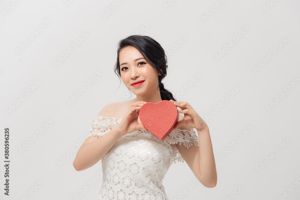 Beautiful young Asian woman holding love gift box isolated over white background.