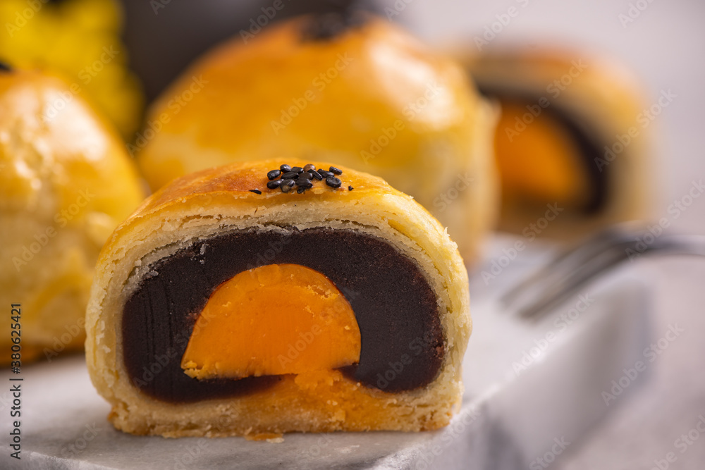 Tasty baked egg yolk pastry moon cake for Mid-Autumn Festival on bright cement table background. Chi