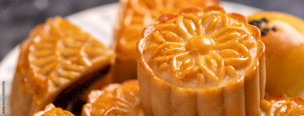 Tasty baked egg yolk pastry moon cake for Mid-Autumn Festival on bright cement table background. Chi