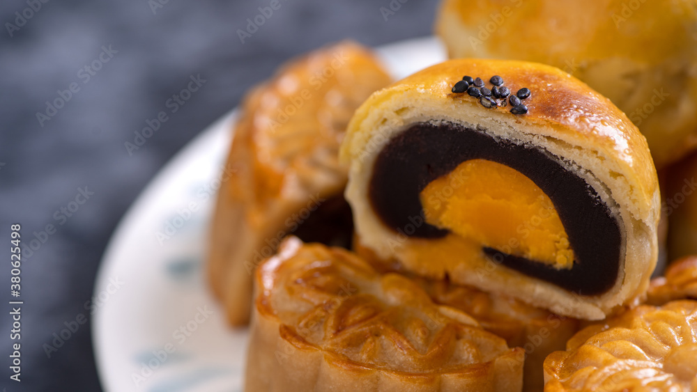 Tasty baked egg yolk pastry moon cake for Mid-Autumn Festival on bright cement table background. Chi