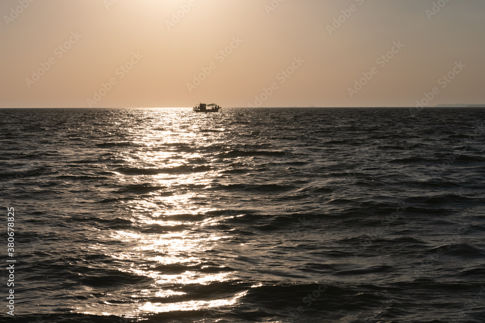 Lonely fishing ship trawler boat on ocean water. Calm clear sea sunny weather. Beautiful horizon of 