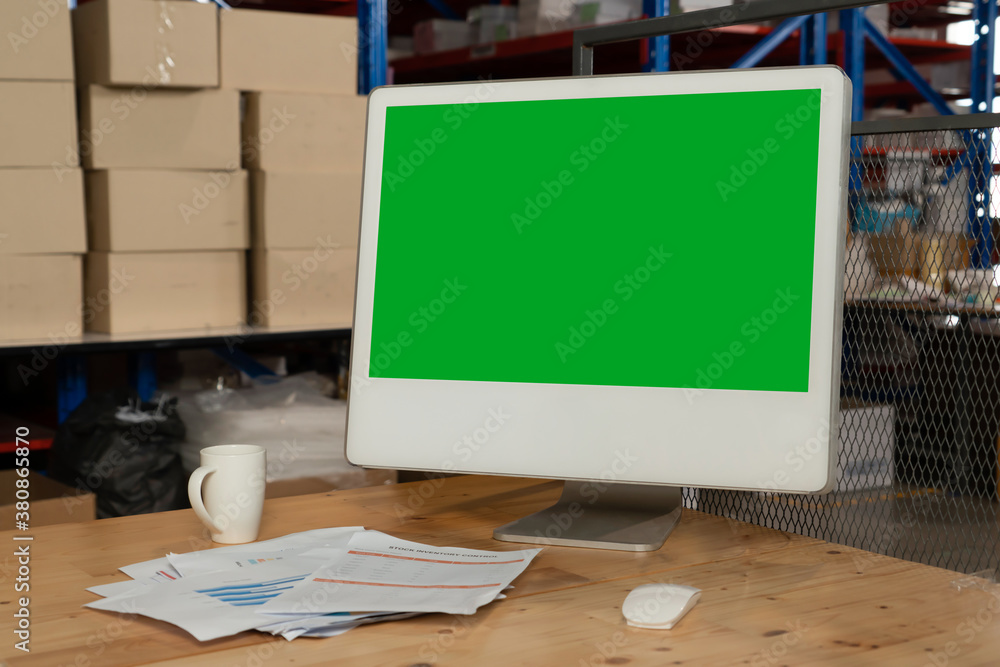 Computer with green screen display in warehouse storage room . Delivery and transportation software 