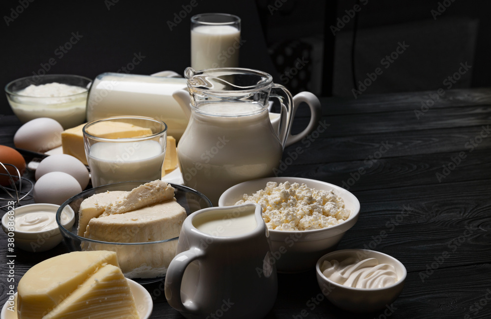 Dairy products on black wooden background with copy space