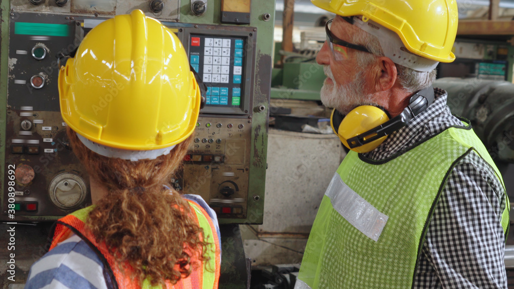 Group of factory workers using machine equipment in factory workshop . Industry and engineering conc