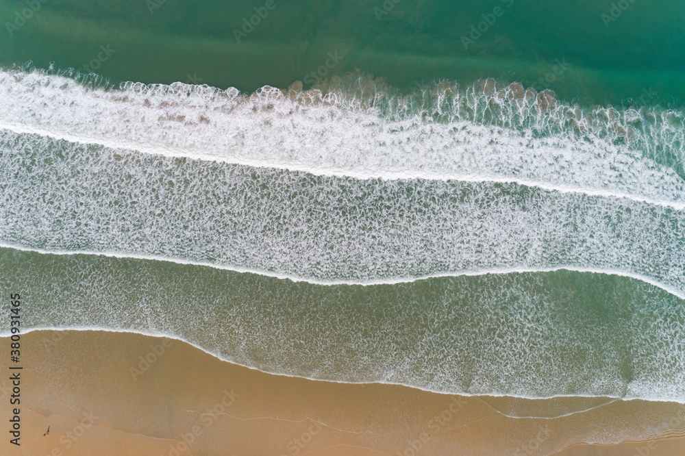 Aerial view sandy beach and crashing waves on sandy shore Beautiful tropical sea in the morning summ