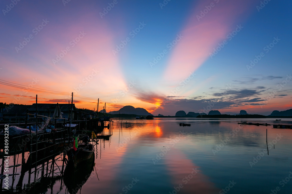 Longtail boat with coastal fishing village,Beautiful scenery view in morning sunrise over sea and mo