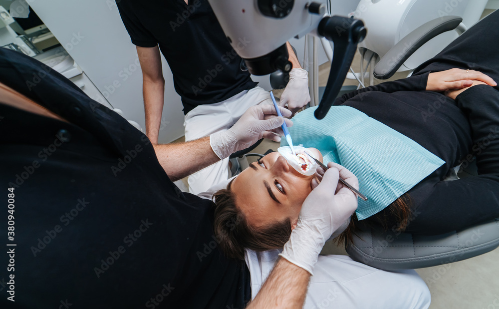 Dentist examines patients teeth with a dental microscope. Modern medical equipment. Oral treatment 