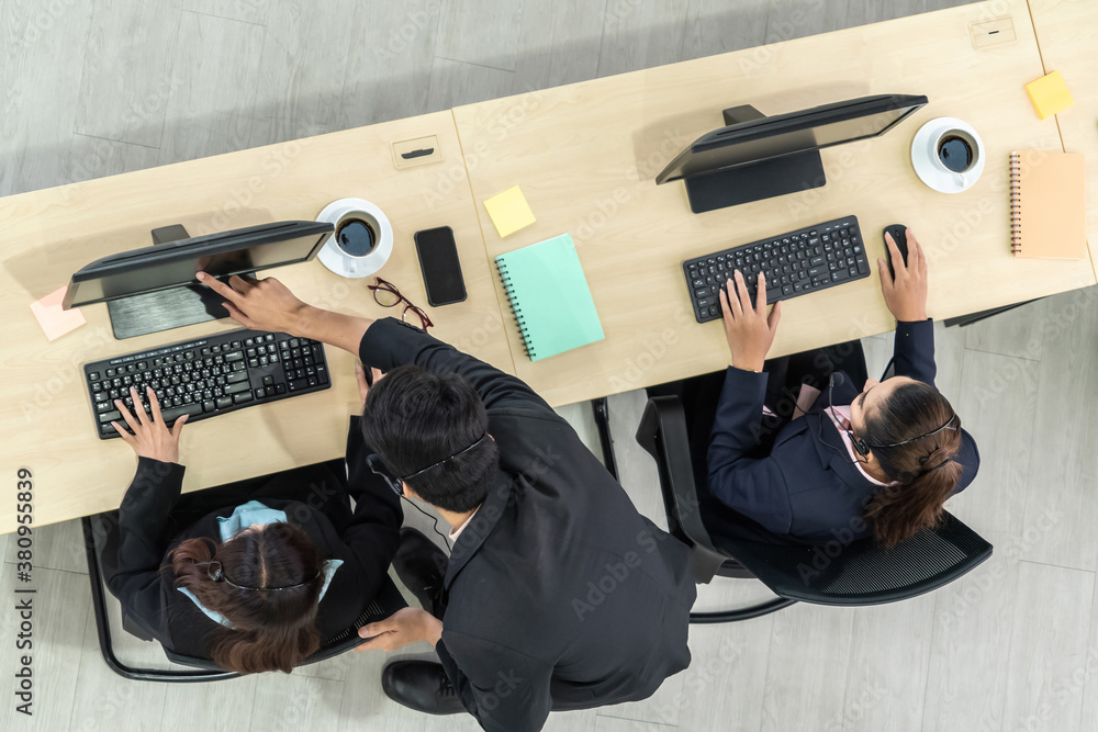 Business people wearing headset from top view in office working with computer to support remote cust