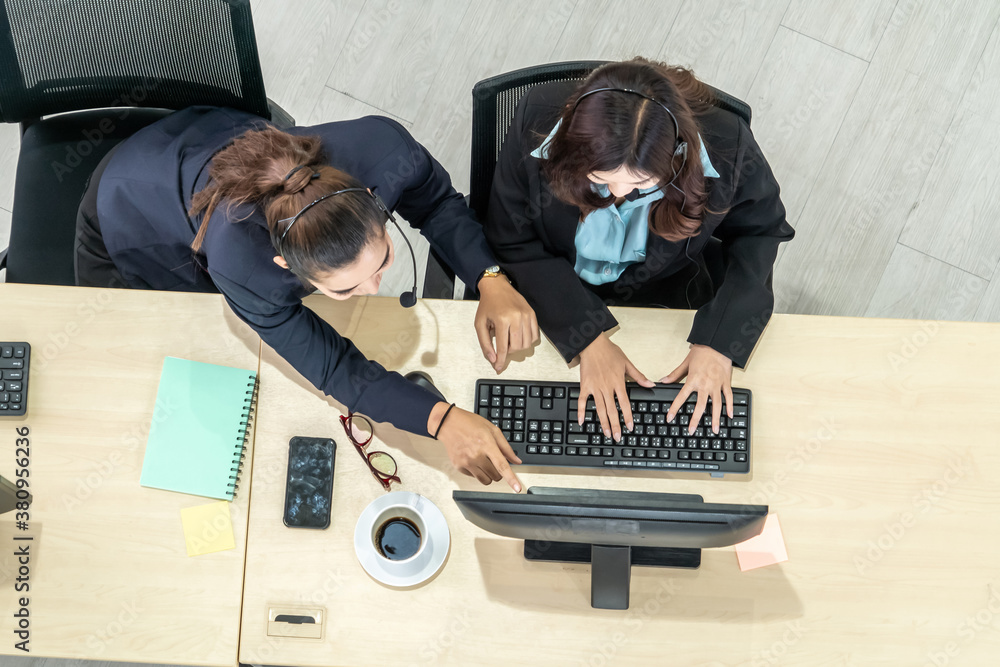 Business people wearing headset from top view in office working with computer to support remote cust