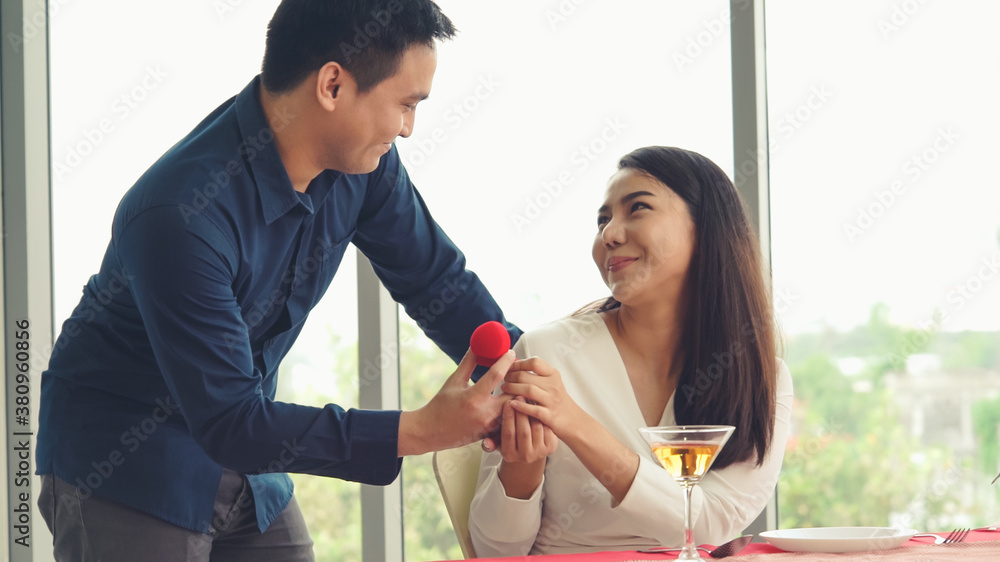 Romantic couple giving gift to lover at restaurant . Happy couple lifestyle .