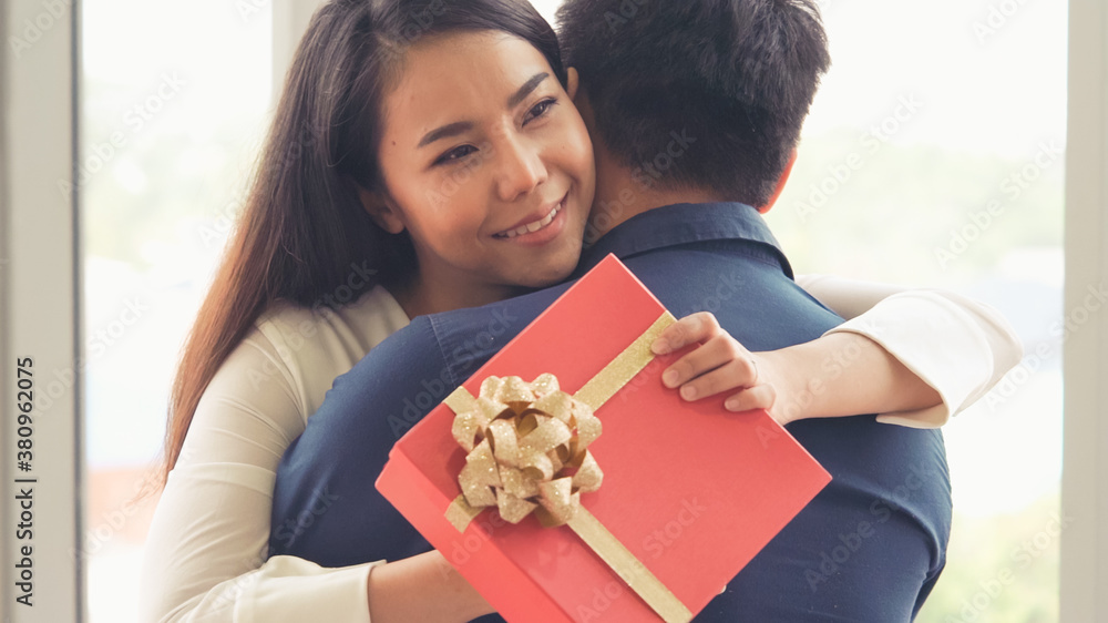 Romantic couple giving gift to lover at restaurant . Happy couple lifestyle .