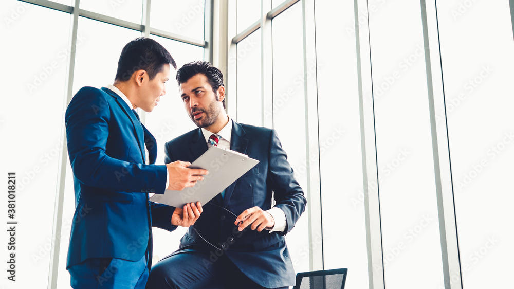 Two business people talk project strategy at office meeting room. Businessman discuss project planni