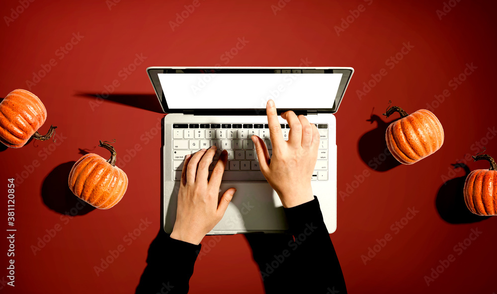 Autumn pumpkins with person using a laptop computer from above