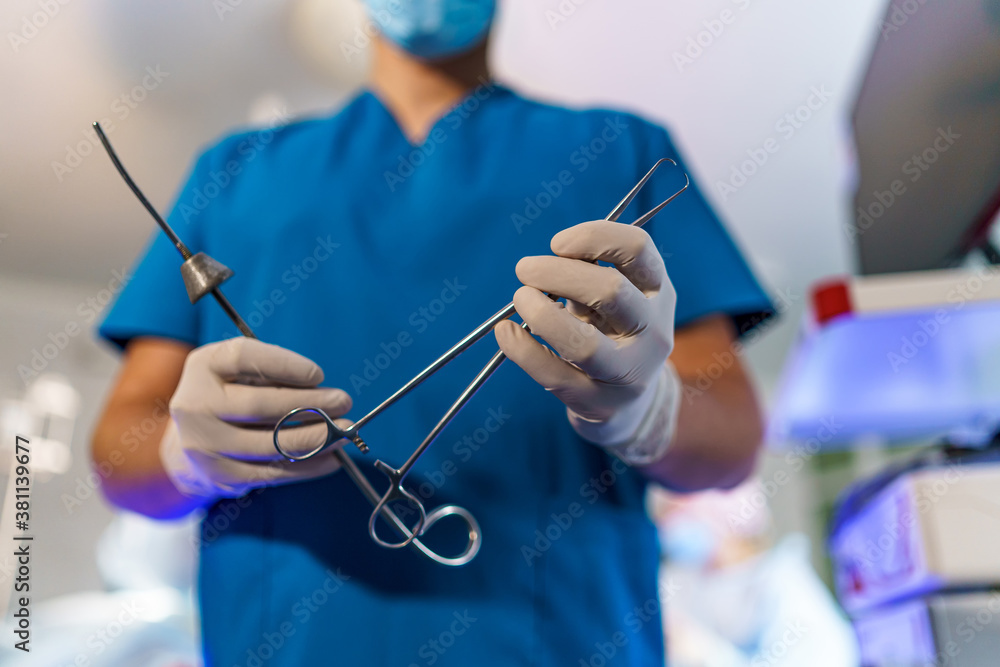 Surgeon`s hands taking scissors, forceps or surgical instruments. Operation in hospital. Emergency c