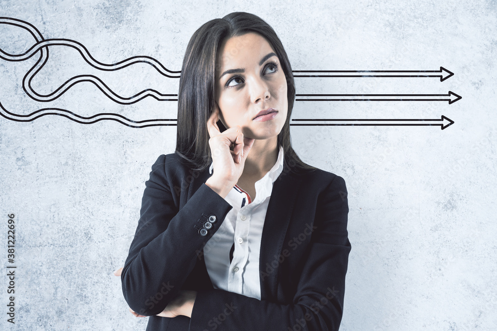 Businesswoman and drawing arrows on concrete wall.