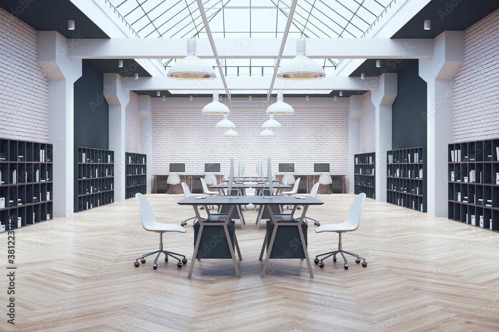 Coworking office in loft style with large skylight,  computers on table and shelf with documents.