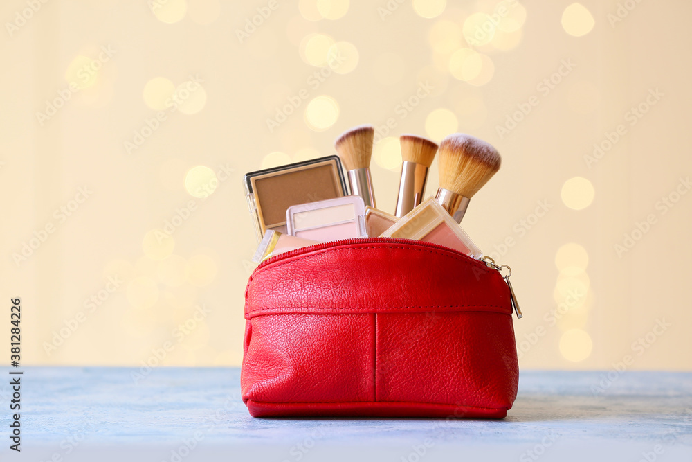 Makeup bag with decorative cosmetics on table