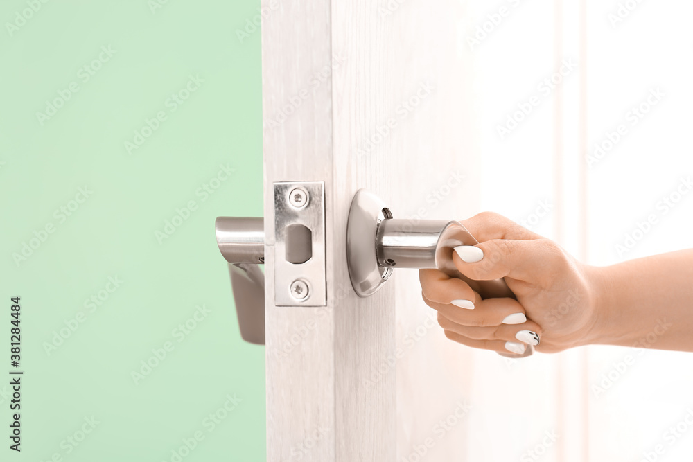 Woman opening door indoors, closeup