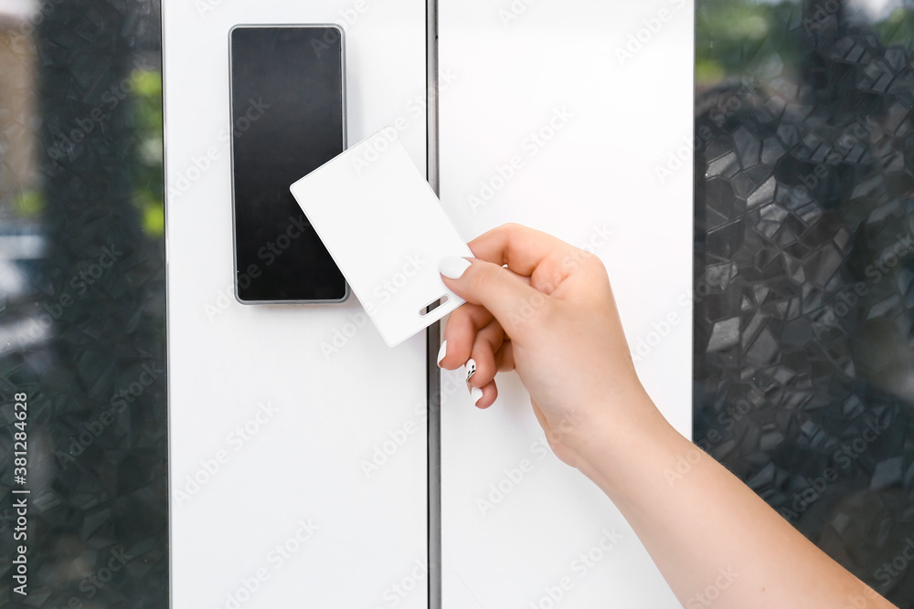 Woman using card to open door outdoors