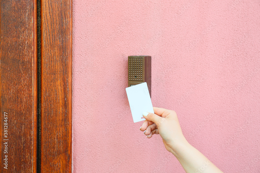 Woman using card to open door outdoors