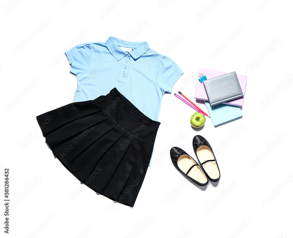 Stylish school uniform with stationery on white background