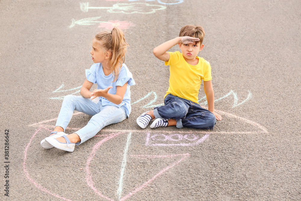 Little children sitting on chalk drawing of ship outdoors