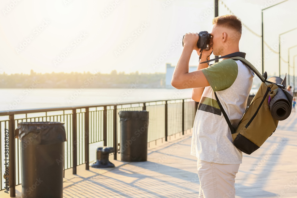 Male tourist taking photo on city street