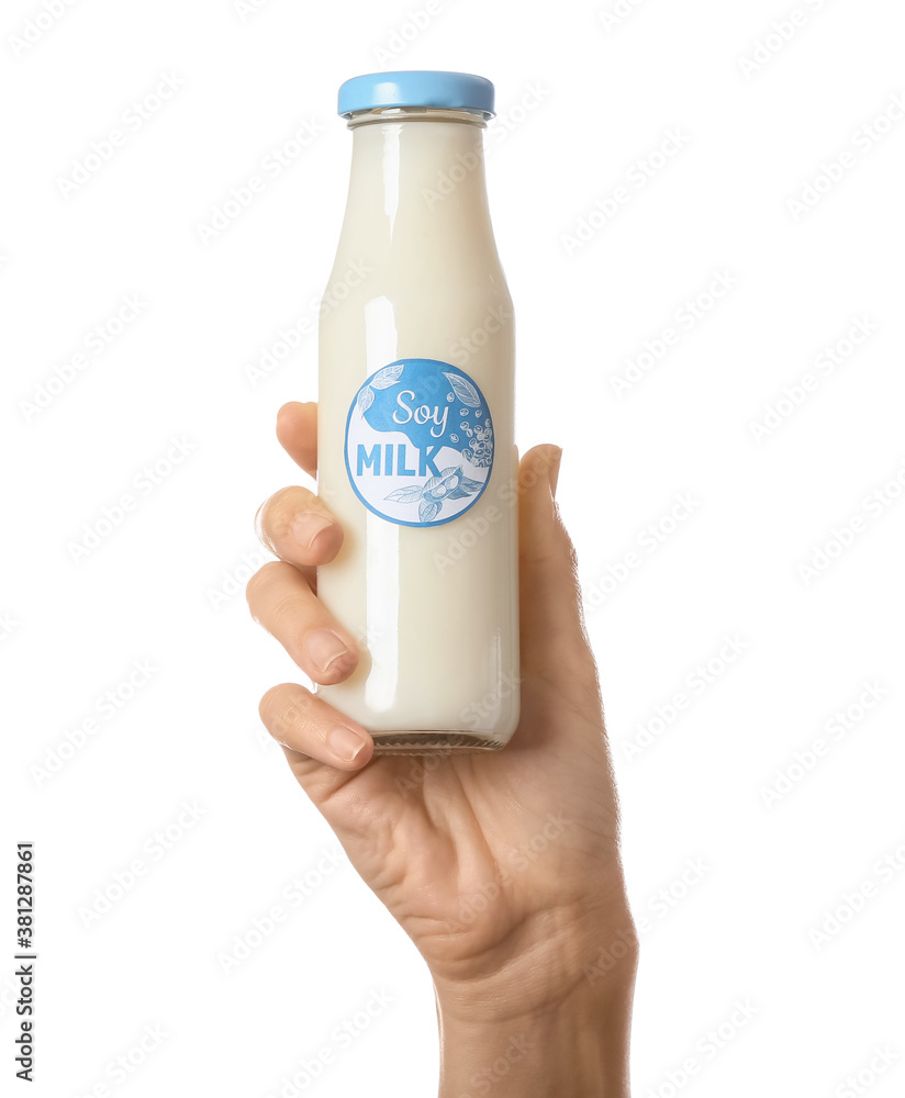 Female hand with bottle of soy milk on white background