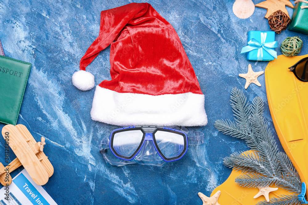 Composition with Santa Claus hat and snorkeling mask on color background